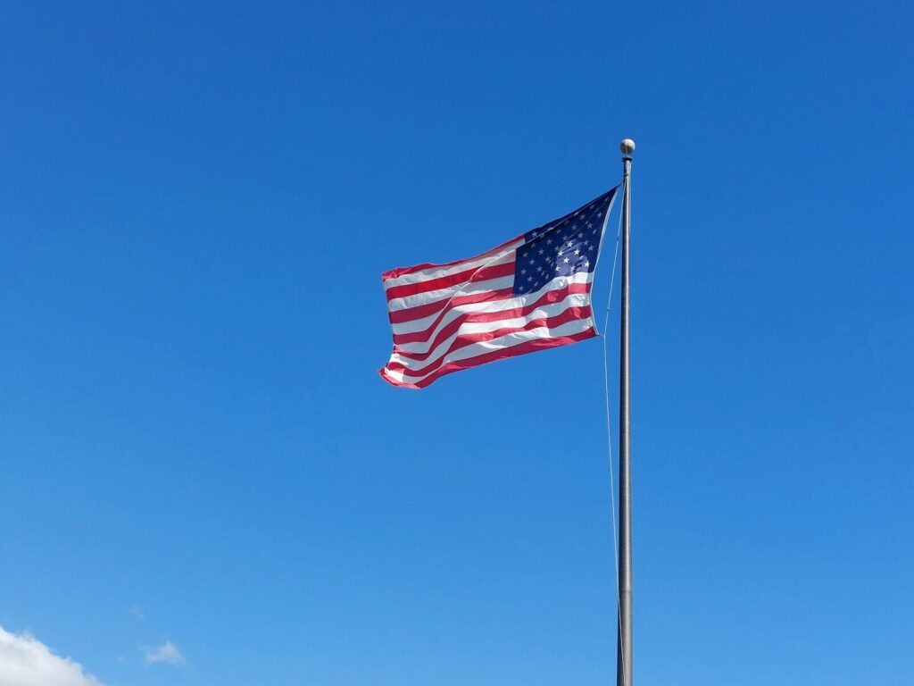 an american flag flying in the wind on a clear day