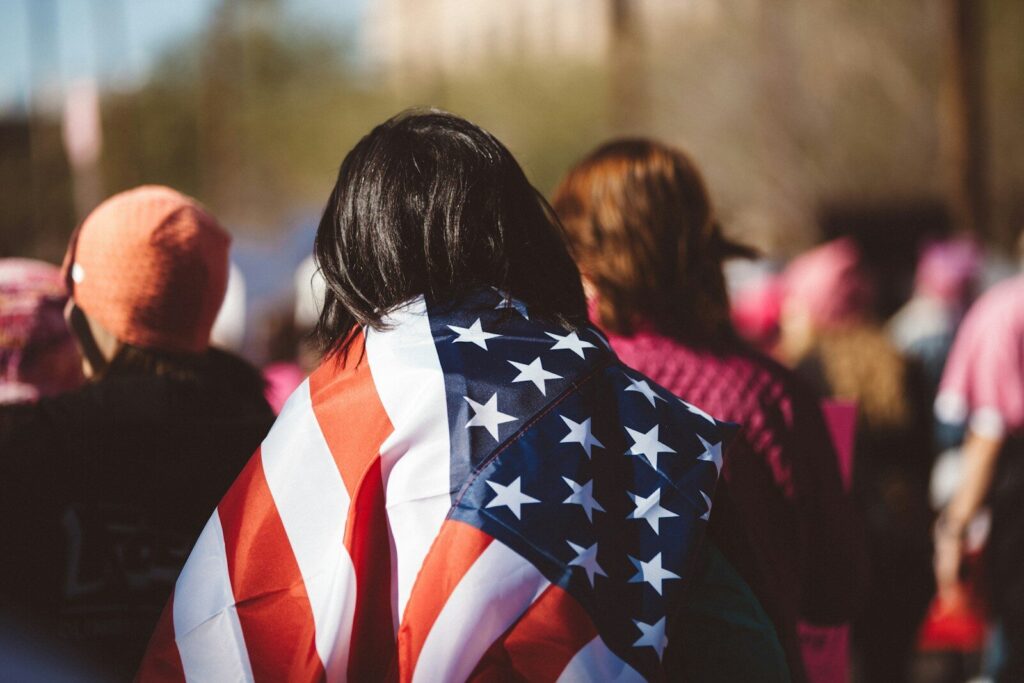 The Role of Agriculture in the U.S. Economy: More Than Just Farming woman with US American flag on her shoulders